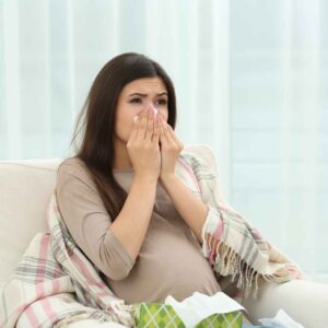 An image of a woman wiping her nose showing the importance of testing your home for allergens.